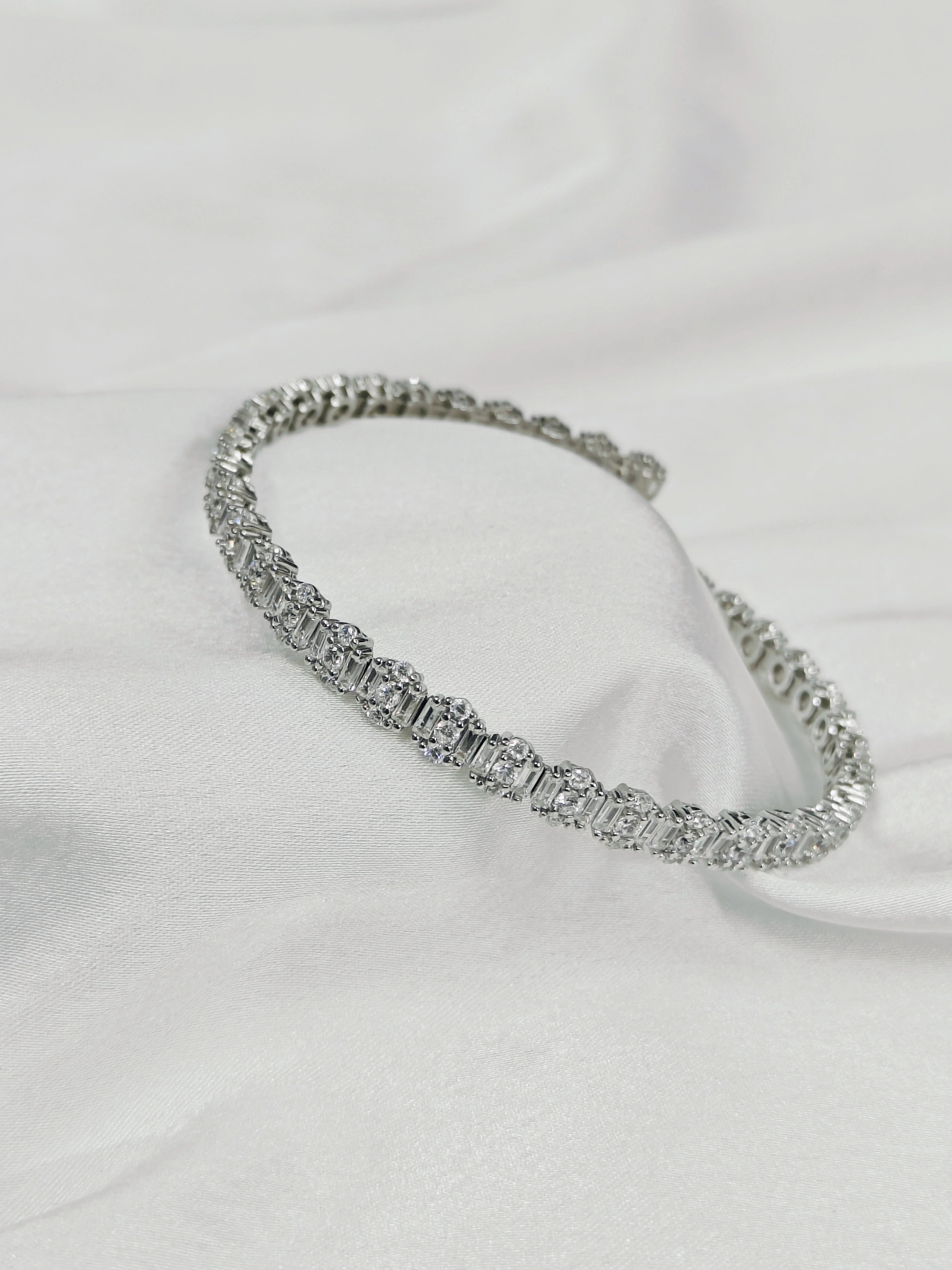Silver bracelet on a white fabric background